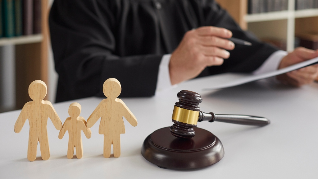 wooden figurines of family with child and judge's gavel