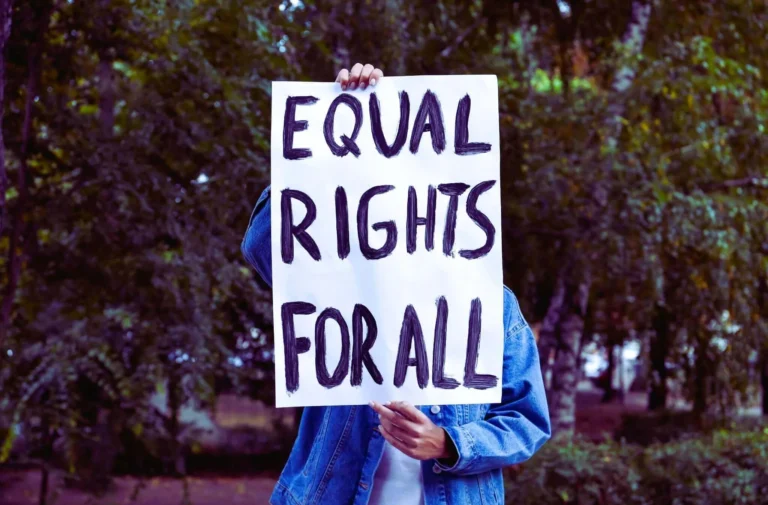 a person holding a sign saying "Equal Rights For All"