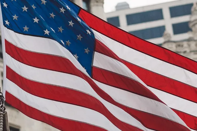 American flag waving in front of a city building